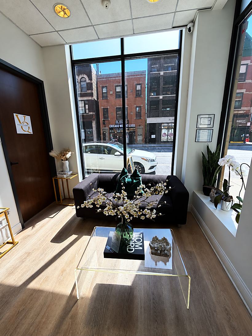 The front lounge and entry, with a sofa under the storefront window onto Halsted Street